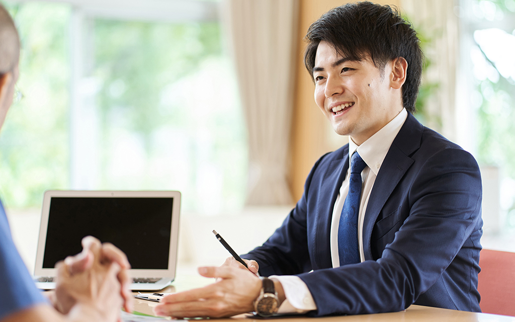 Light UPのスライダー画像。提案をする営業の若い男性社員。