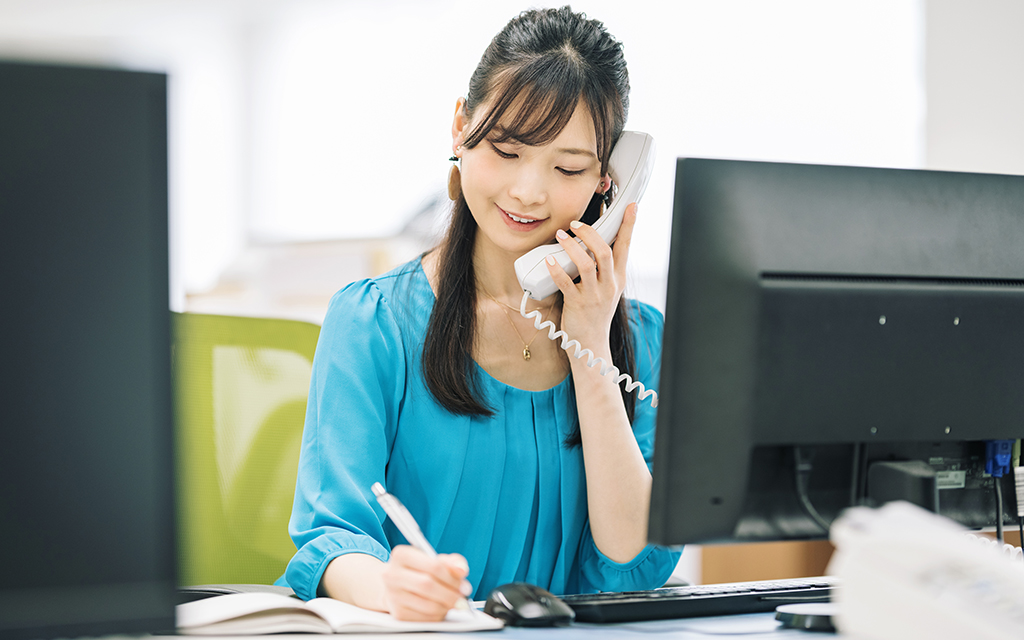 Light UPのスライダー画像。電話をしながらメモを取る女性社員。