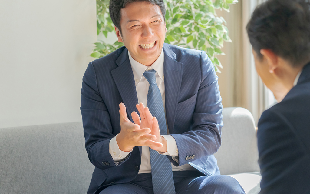 Light UPのスライダー画像。提案をする営業の男性社員。