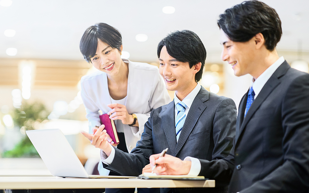 Light UPのスライダー画像。企画作成中に、意見を出し合う若い社員達。